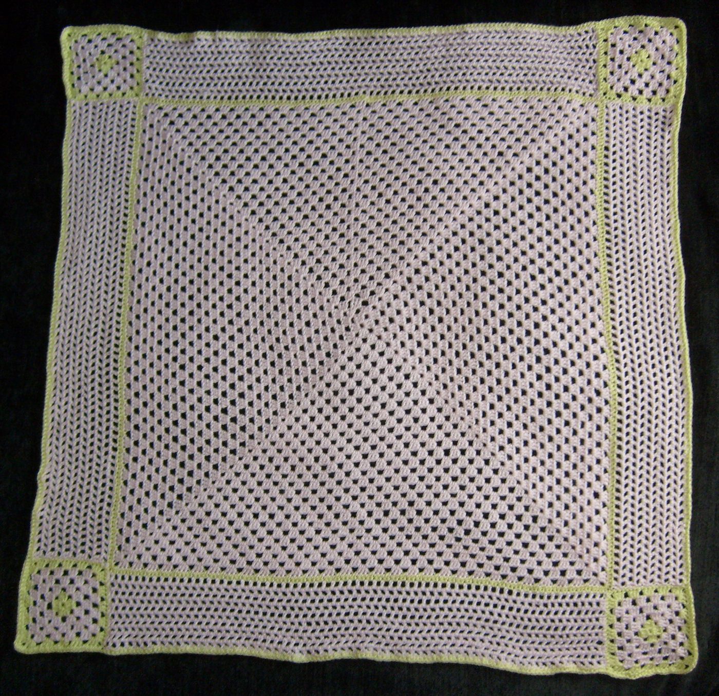 Handmade crochet baby blanket laid flat