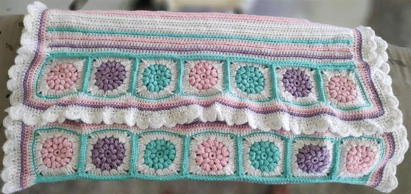 Colorful crochet blanket spread out horizontally