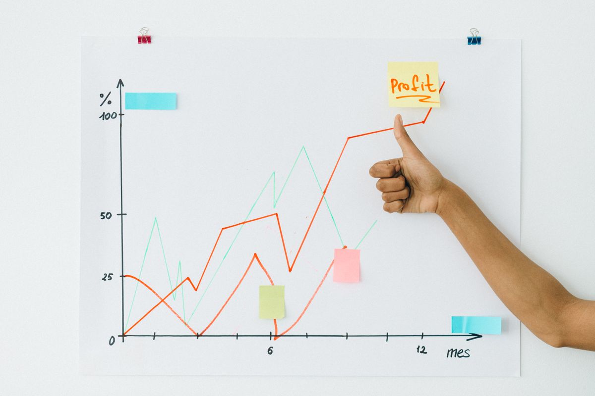 Hand pointing to a rising chart that illustrates steady growth over time