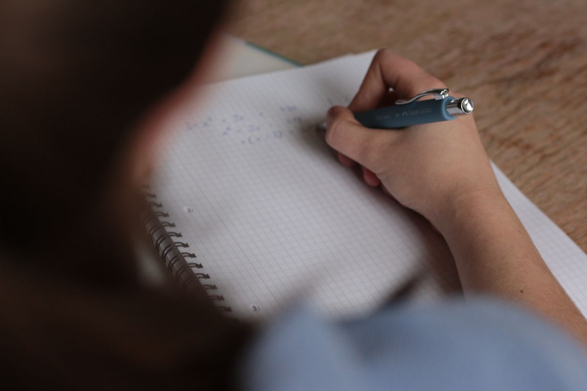 Handwritten math equations in a notebook for solving algebra problems